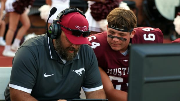 Position coach Tony Chesney and Kayden Snyder look over film on the sideline.